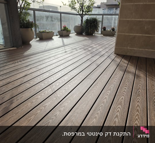 רצפת עץ עם עציצים במרפסת שמש